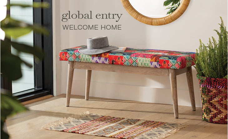 Lifestyle Image of Kantha Bench with plant on side and hat on top. global entry WELCOME HOME