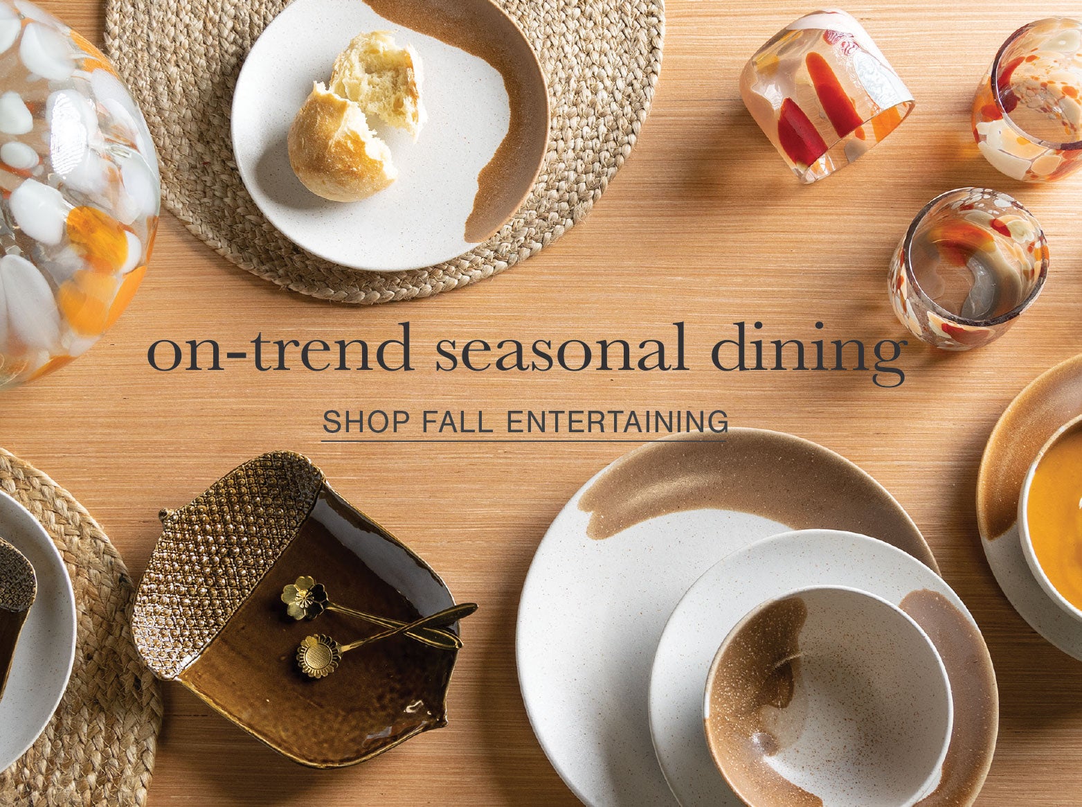 A table is set with Brown Dip dinnerware, acorn serving plate and fall colored glassware. On-trend seasonal dining. Shop fall entertaining.