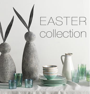 EASTER COLLECTION - Image of a contemporary easter table setting with gray stone bunny sculptures, aqua recycled glassware and cream and aqua ceramic dishes.