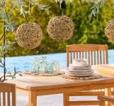 An outdoor dining table set with lanterns and coastal dinnerware